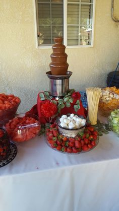 a table with strawberries, marshmallows and chocolate fountain