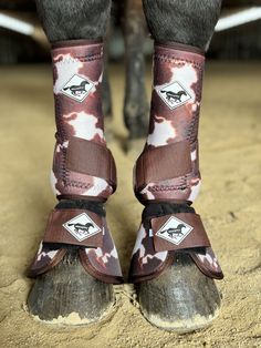 the legs and feet of a horse wearing boots with an animal print pattern on them