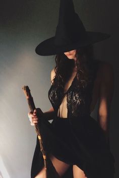 a woman in a witch costume holding a broom