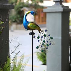 a colorful peacock statue on top of a metal pole