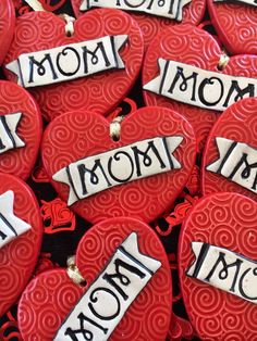 many red heart shaped cookies with black writing on them and hearts in the shape of hearts