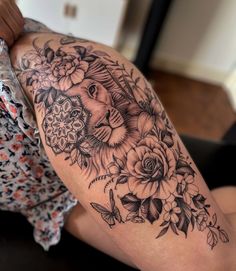 a woman's arm with flowers and a lion tattoo on the left side of her arm