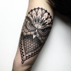 an owl tattoo on the arm