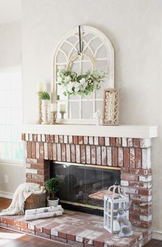 a living room with a brick fireplace and white flowers on top of the mantel