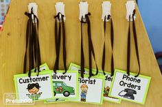 four tags with the words customer, delivery and phone orders hanging from them on a wooden table