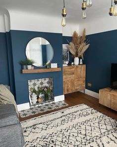 a living room with blue walls and a white rug in front of the fireplace area