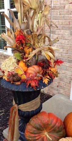 a vase filled with lots of different types of fall decorations