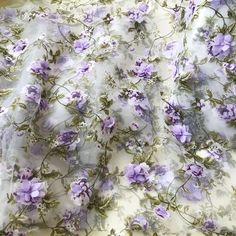 the fabric has purple flowers on it