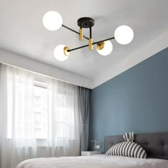 a bed room with a neatly made bed and four lights hanging from the headboard