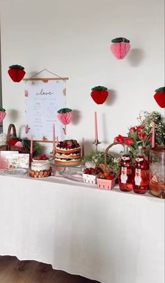 a table topped with cakes and desserts on top of a white cloth covered table