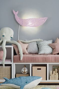 an octopus lamp sitting on top of a bed next to pillows and other items in front of it