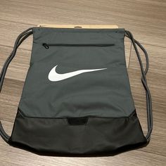 Gray Nike Drawstring Bag New With Tags Has A Zipper In The Front And The Nike Emblem Nike Drawstring Bag, Casual Gray Backpack For Sports, Casual Gray Sports Backpack, Casual Gray Gym Bag For Daily Use, Sporty Gray Sports Bags, Sporty Gray Gym Bag, Nike Black Backpack For Gym, Nike Black Gym Backpack, Sporty Gray Bags For Daily Use