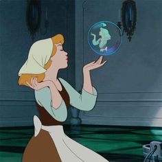 a woman in a brown and white dress holding a glass ball with an image of a mermaid on it