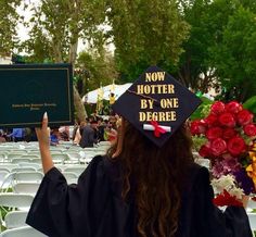 a person in a graduation cap holding up a sign