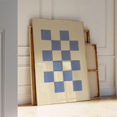 an art piece sitting on the floor in front of a frame with squares painted on it