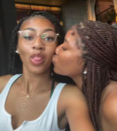 two women are kissing each other while wearing glasses