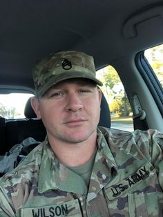 a man in uniform sitting in the back seat of a car