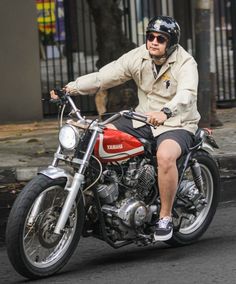 a man riding on the back of a red motorcycle