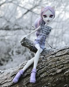 a doll sitting on top of a tree branch