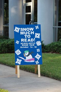 a blue sign sitting on the side of a sidewalk