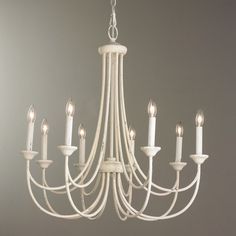 a white chandelier with candles hanging from it's sides and the words shades of light above it