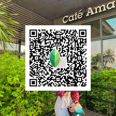 a woman is holding up a qr code