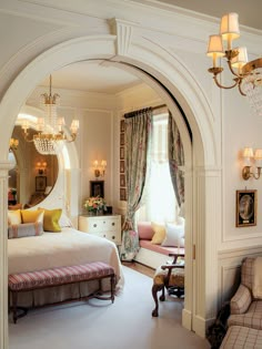 a bedroom with a bed, chair and chandelier in the middle of it