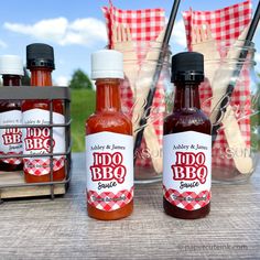 three bottles of bbq sauce sitting on a table