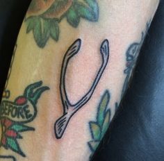 a close up of a person's arm with tattoos on it and scissors in the middle