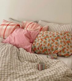 a bed topped with lots of pillows and blankets