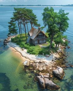 an island with a house on it in the middle of the water surrounded by rocks and trees