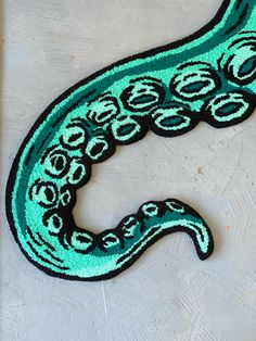 a green and black rug with an octopus on it