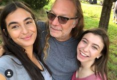 two girls and an older man posing for the camera