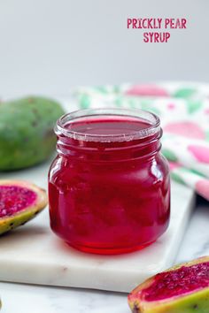 a jar of pickled pear syrup on a cutting board next to sliced figs