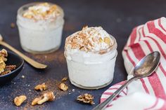 two desserts are sitting on a table with spoons