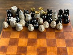 a chess board with several black and white cats on it's sides, all lined up in the same row