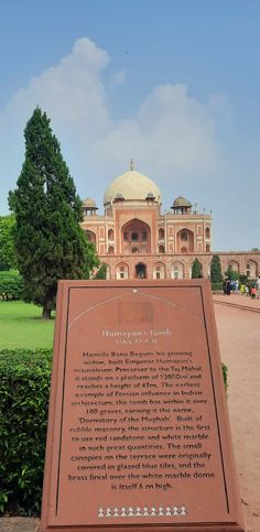 a sign in front of a large building with a dome on it's roof