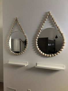 there are two mirrors on the wall and one is made out of wood bead