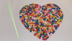 a heart shaped cake with sprinkles on the side and a green straw