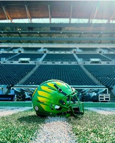 a football helmet sitting on top of a field next to an empty bleachers