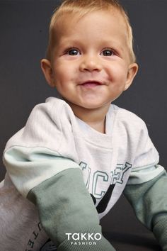 a young boy is smiling for the camera