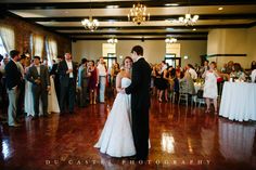 a bride and groom sharing their first dance at their wedding reception in front of an audience