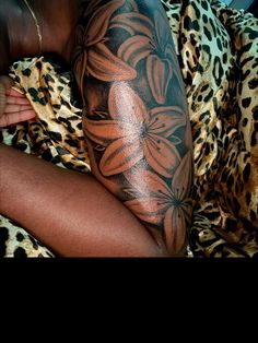 a woman laying on top of a leopard print blanket next to a flower tattoo design