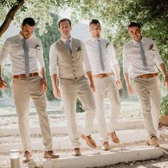 four men in white shirts and ties are posing for the camera