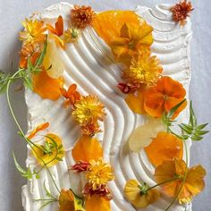 a white cake with orange and yellow flowers on it