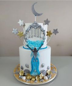 there is a cake that has been decorated with shells and stars on the top tier