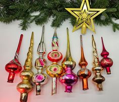 there are many different colored glass ornaments on the wall next to a star ornament