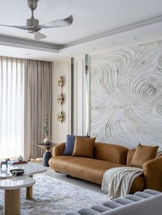 a living room filled with furniture and a large wall mounted art piece on the wall