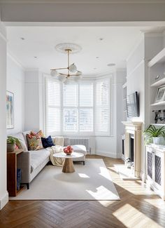 an image of a living room setting with white furniture and wood floors in the foreground