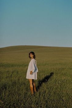 a woman standing in the middle of a field